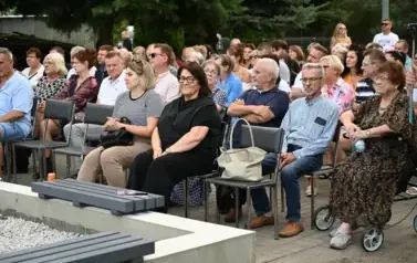 widzimy liczną grupę os&oacute;b siedzącą na krzesłach