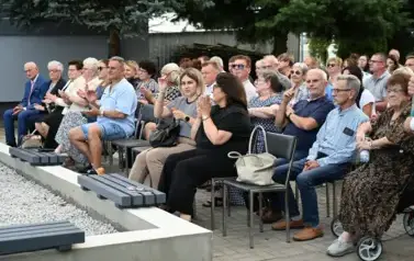 widzimy liczną grupę os&oacute;b siedzącą na krzesłach