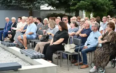 widzimy liczną grupę os&oacute;b siedzącą na krzesłach