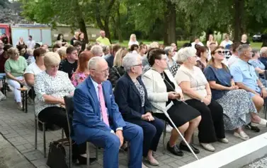 widzimy liczną grupę os&oacute;b siedzącą na krzesłach