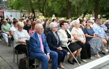 widzimy siedzące osoby na krzesłach
