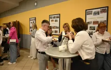 widzimy grupę os&oacute;b jedzące tort