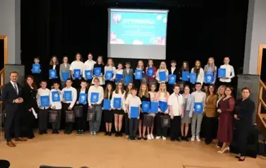 widzimy grupę dzieci, kt&oacute;re otrzymały stypendia oraz organizator&oacute;w