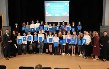 widzimy grupę dzieci, kt&oacute;re otrzymały stypendia oraz organizator&oacute;w