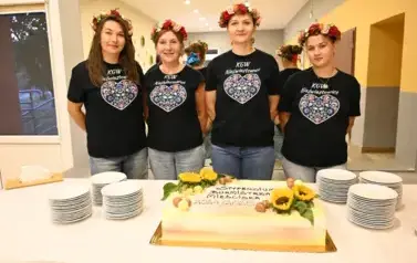 widzimy 4 panie stojące przy torcie we wiankach oraz w ludowych koszulkach 