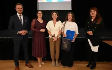 widzimy 3 panie, pana oraz dziewczynkę, kt&oacute;ra otrzymała stypendium i upominek