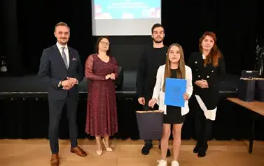 widzimy 2 panie, 2 pan&oacute;w oraz dziewczynke, kt&oacute;ra otrzymała stypendium oraz upominek