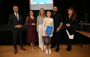 widzimy 3 panie, 2 pan&oacute;w oraz dziewczynke, kt&oacute;ra otrzymała stypendium