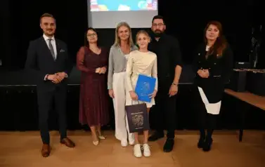 widzimy 3 panie, 2 pan&oacute;w oraz dziewczynke, kt&oacute;ra otrzymała stypendium