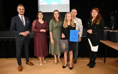 widzimy 3 panie, 2 pan&oacute;w oraz dziewczynke, kt&oacute;ra otrzymała stypendium