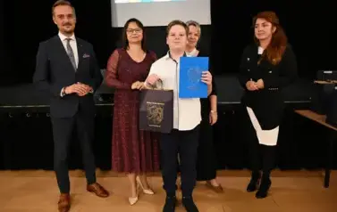 widzimy 3 panie, pana oraz chłopca, kt&oacute;ry otrzymał stypendium i podarunek