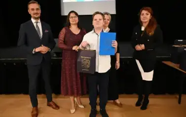 widzimy 3 panie, pana oraz chłopca, kt&oacute;ry otrzymał stypendium i podarunek