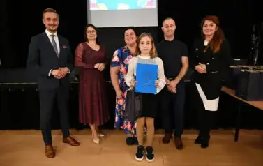 widzimy 3 panie, 2 pan&oacute;w oraz dziewczynke, kt&oacute;ra otrzymała stypendium