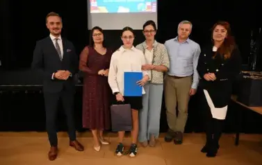 widzimy 3 panie, 2 pan&oacute;w oraz dziewczynkę, kt&oacute;ra otrzymała stypendium