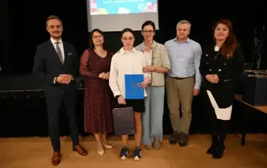 widzimy 3 panie, 2 pan&oacute;w oraz dziewczynkę, kt&oacute;ra otrzymała stypendium