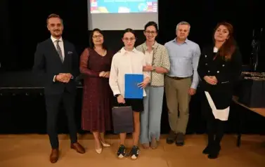widzimy 3 panie, 2 pan&oacute;w oraz dziewczynkę, kt&oacute;ra otrzymała stypendium