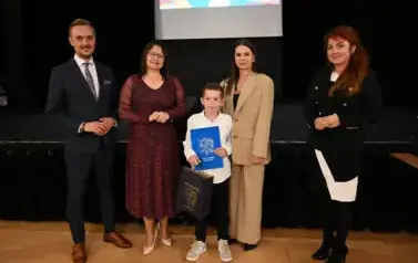 widzimy 3 panie, pana oraz chłopca, kt&oacute;ry otrzymał stypendium i podarunek