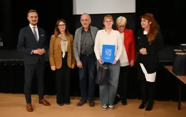 widzimy 3 panie, 2 pan&oacute;w oraz dziewczyne, kt&oacute;ra otrzymała stypendium oraz podarunek