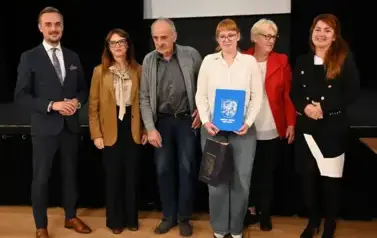 widzimy 3 panie, 2 pan&oacute;w oraz dziewczyne, kt&oacute;ra otrzymała stypendium oraz podarunek