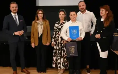 widzimy 3 panie, 2 pan&oacute;w oraz chłopca, kt&oacute;ry otrzymał stypendium oraz podarunek