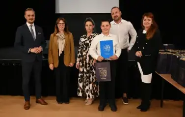widzimy 3 panie, 2 pan&oacute;w oraz chłopca, kt&oacute;ry otrzymał stypendium oraz podarunek