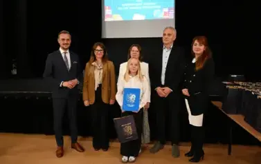 widzimy 3 panie, 2 pan&oacute;w oraz dziewczynke, kt&oacute;ra otrzymała stypendium oraz podarunek