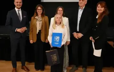 widzimy 3 panie, 2 pan&oacute;w oraz dziewczynke, kt&oacute;ra otrzymała stypendium oraz podarunek