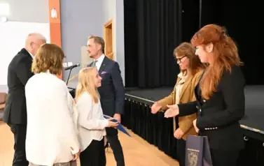 widzimy 3 panie, 2 pan&oacute;w oraz dziewczynke, kt&oacute;ra otrzymała stypendium