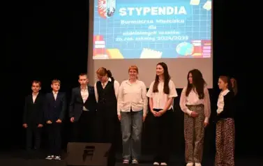 wiczymy 5 dziewczynek oraz 3 chłopc&oacute;w stojących na scenie