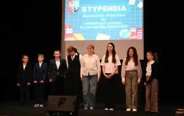 wiczymy 5 dziewczynek oraz 3 chłopc&oacute;w stojących na scenie