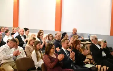 widzimy siedzącą oraz klaszczącą w dłonie publiczność