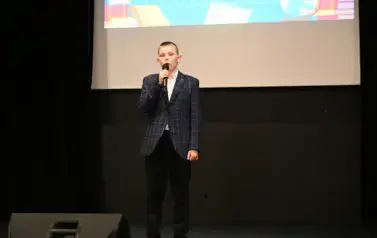 widzimy chłopca m&oacute;wiącego do mikrofonu