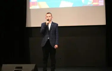widzimy chłopca m&oacute;wiącego do mikrofonu