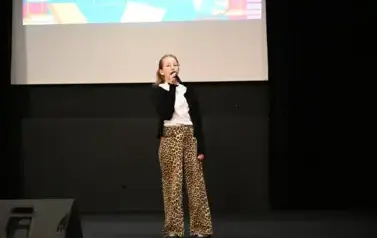 widzimy dziewczynke śpiewającą na scenie