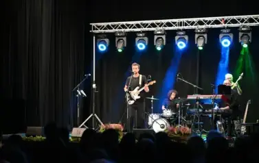 widzimy pan&oacute;w grających na instrumentach, jeden z pan&oacute;w gra na gitarze i śpiewa