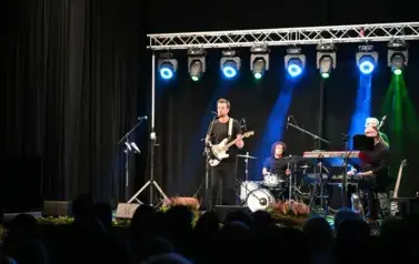 widzimy pan&oacute;w grających na instrumentach, jeden z pan&oacute;w gra na gitarze i śpiewa