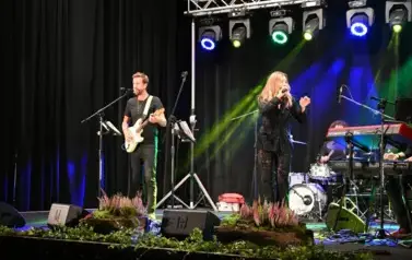 widzimy panią śpiewającą na scenie oraz pana grającego na gitarze