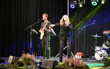 widzimy panią śpiewającą na scenie oraz pana grającego na gitarze