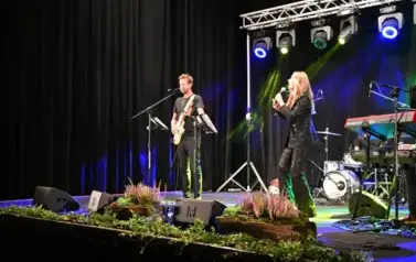 widzimy panią śpiewającą na scenie oraz pana grającego na gitarze