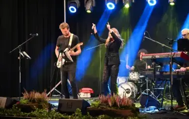 widzimy panią tańczącąna na scenie oraz pana grającego na gitarze