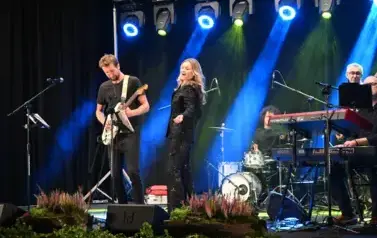 widzimy panią tańczącąna na scenie oraz pana grającego na gitarze