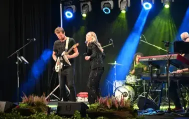 widzimy panią tańczącąna na scenie oraz pana grającego na gitarze