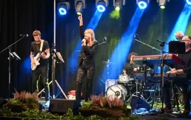widzimy panią śpiewającą do mikrofonu oraz pana grającego na gitarze