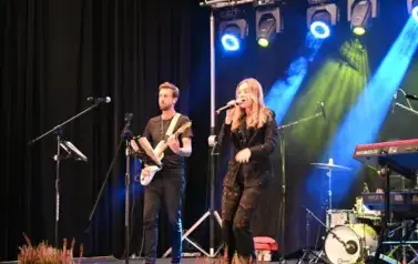 widzimy panią śpiewającą do mikrofonu oraz pana grającego na gitarze