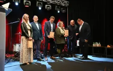 widzimy osoby stojące z upominkami w rękach