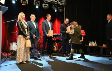 widzimy pana przekazującego upominki osobą na scenie