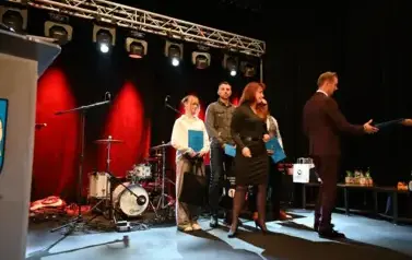 widzimy pana, panią oraz 3 osoby stojące z podarunkami w rękach
