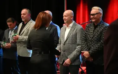 widzimy panią wręczającą kubki osobą stojącym w rzędzie