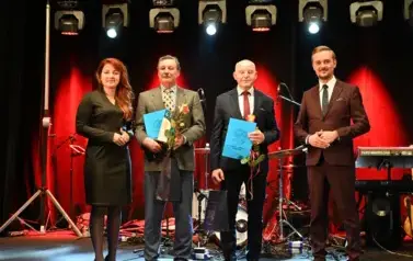 widzimy pana, panią oraz dw&oacute;ch pan&oacute;w z podarunkiem w rękach