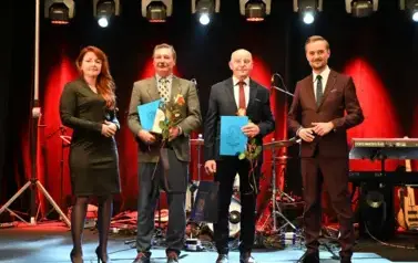 widzimy pana, panią oraz dw&oacute;ch pan&oacute;w z podarunkiem w rękach